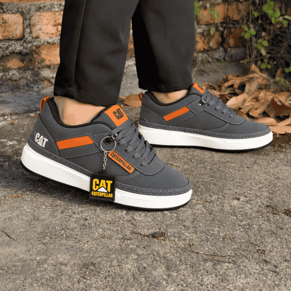 Zapatillas CAT grises y naranjas al aire libre (1)